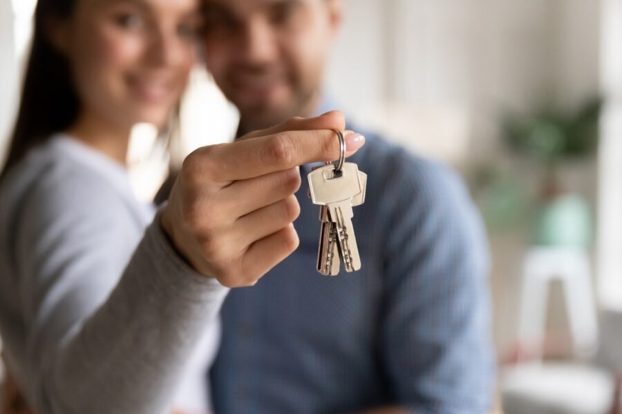 close-up-happy-young-woman-hugging-man-holding-keys