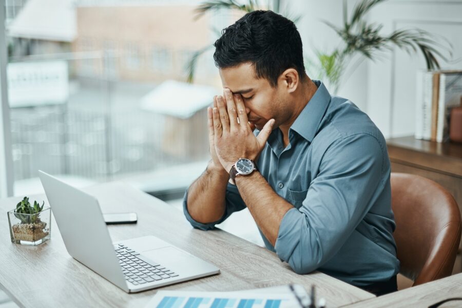 shot-of-a-young-businessman-looking-stressed-while-working-in-a-modern-office