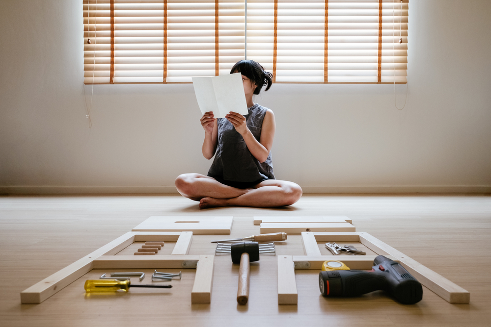 youngasianwomanselfassemblywoodenfurnitureandreadblank