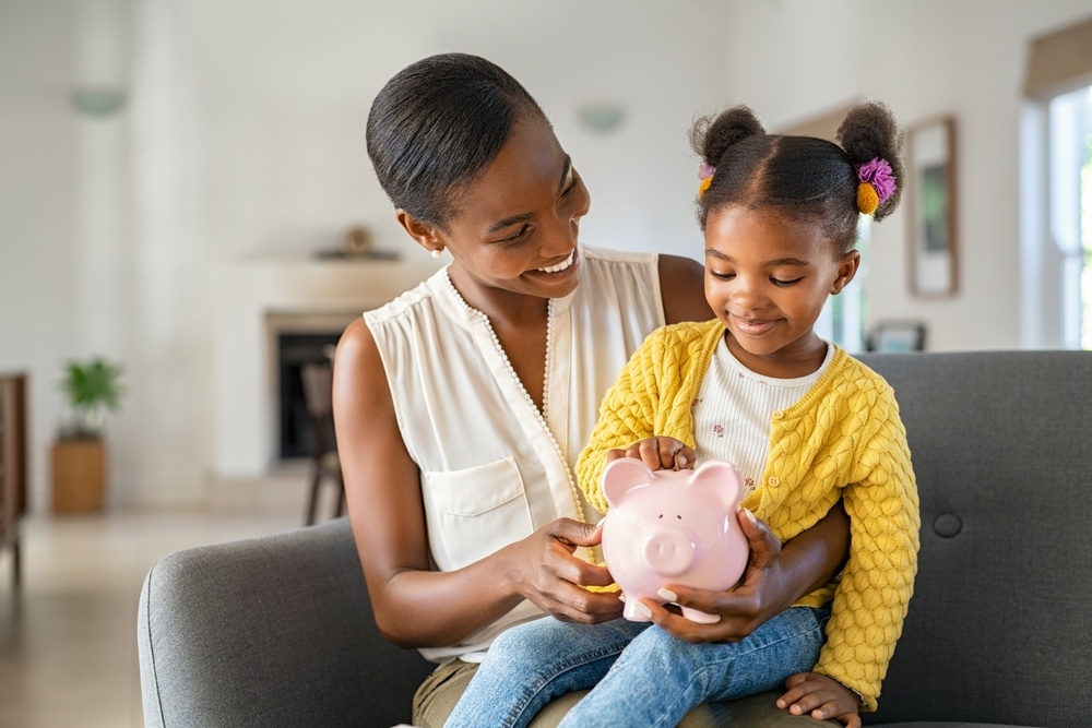 smilingmatureafricanamericanmotherhelpingdaughtersittingonlap